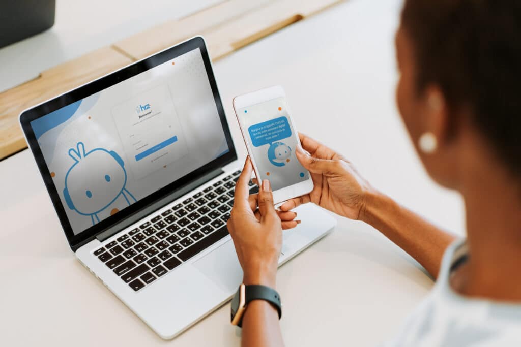 Assistant digital OSCAR : conversation mobile et login. Femme consultant l'assistant digital OSCAR sur smartphone ("Bonjour, je m'appelle OSCAR..."). Laptop affichant la page de connexion hrz.