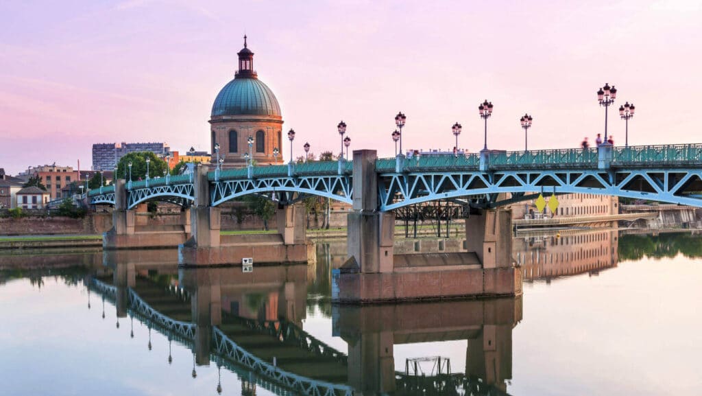 Toulouse : Le Pont Saint-Pierre au crépuscule sur la Garonne Pont Saint-Pierre bleu et sa coupole de La Grave, vus au crépuscule à Toulouse. Les reflets clairs du pont se mêlent à l'eau calme.