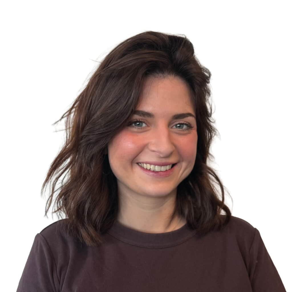 Portrait d'une femme souriante aux cheveux bruns ondulés Femme souriante aux cheveux bruns ondulés portant un t-shirt marron sur fond blanc.